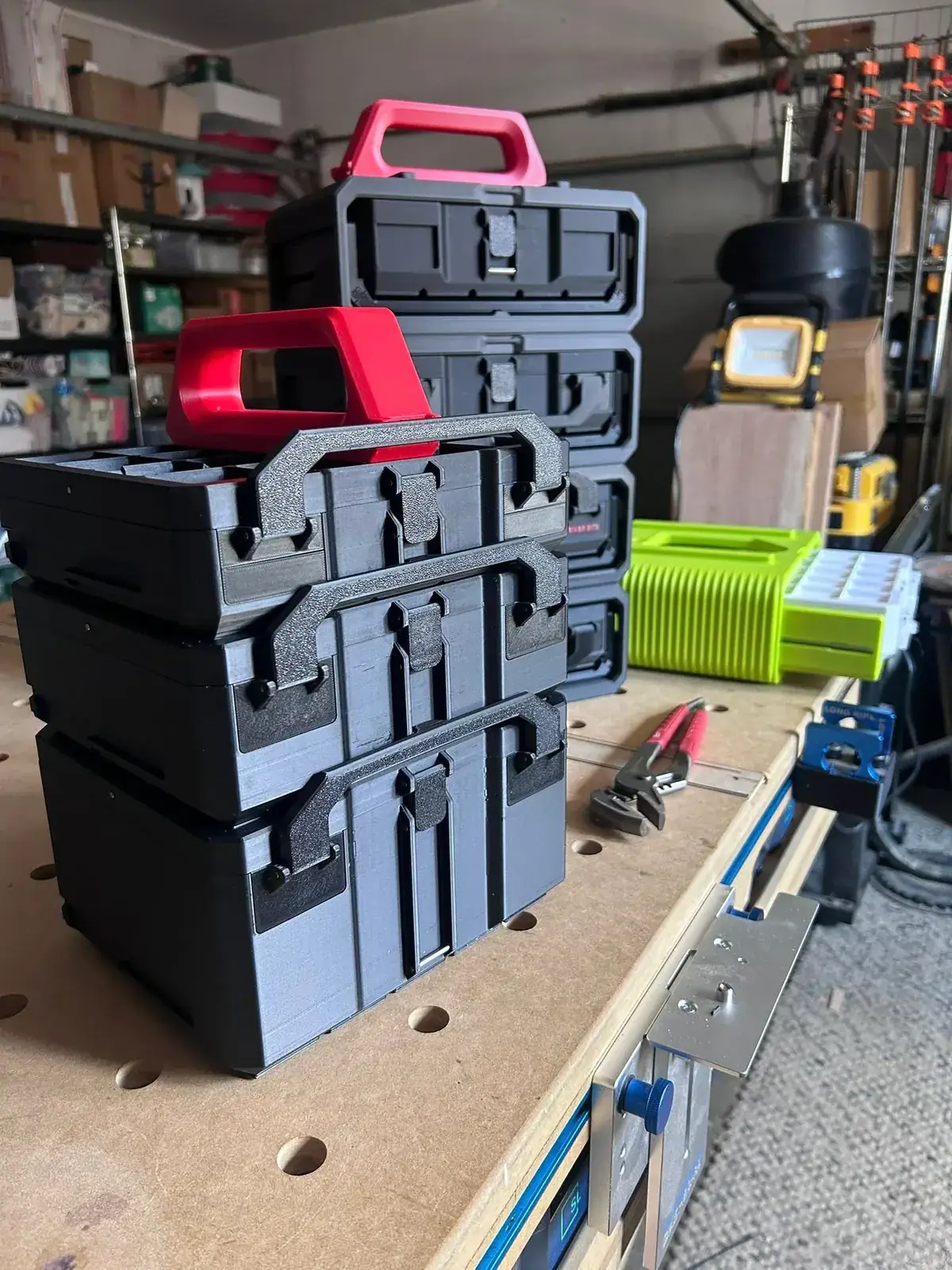 Stacked Graphite Modular storage boxes with carry handles on a workshop bench